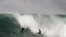 FILE - A surfer watches as a body board rider drops in on his wave at the "Bommie," a famous surfing spot near Sydney's Manly Beach.