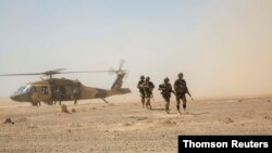지난 2018년 7월 아프간 헬만드주 캠프 쇼라박에서 아프간 공군 소속 블랙호크 헬기에서 내린 아프간 육군대원들이 재보급 임무를 위해 이동하고 있다.
