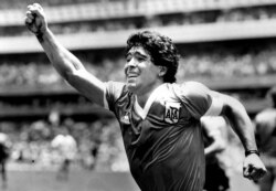 FILE - Argentinian soccer star Diego Maradona raises his arm in the air after scoring a game-winning goal against England in a World Cup semi final in Mexico, June 22, 1986.