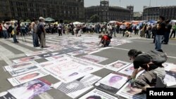 Fotos de personas desaparecidas o asesinadas durante una protesta en el Zócalo de México el 30 de mayo de 2012.