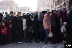 Palestinians wait in a queue to receive bread outside a bakery in Khan Younis on the southern Gaza Strip, Oct. 29, 2024.