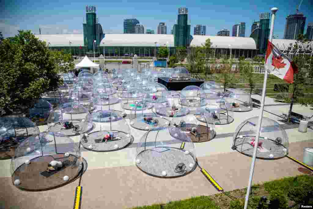 Personas participan en una clase de yoga al aire libre dentro de una c&#250;pula para facilitar el distanciamiento social y protocolos adecuados para prevenir la propagaci&#243;n de la enfermedad del coronavirus (COVID-19), en Toronto, Canad&#225;.