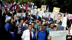 Сирийцы держат фотографии Башара Асада и Владимира Путина, во время митинга у российского посольства. Дамаск, Сирия, 13 октября 2015.