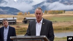 FILE - U.S. Interior Secretary Ryan Zinke announces a ban on mining claims north of Yellowstone National Park as K.C. Walsh, left, president of Simms Fishing Products, listens near Emigrant, Mont., Oct. 8, 2018.