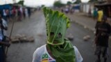 A protester wears a mask made from a leaf in the Cibitoke neighborhood of Bujumbura, Burundi. Protesters dismissed a constitutional court ruling that cleared President Pierre Nkurunziza to run for a controversial third term, as the government offered to release activists if deadly demonstrations stopped.