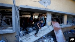 Palestinians search for the bodies of their relatives killed in an Israeli bombardment of a school in Deir al-Balah, central Gaza Strip, Oct. 10, 2024.