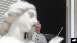 Pope Francis delivers his blessing as he recites the Regina Caeli noon prayer from the window of his studio overlooking St.Peter's Square, at the Vatican, April 18, 2021.