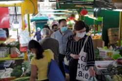 People with protective masks walk at a market at the financial Central district, following the novel coronavirus disease (COVID-19) outbreak, in Hong Kong, China, March 27, 2020.