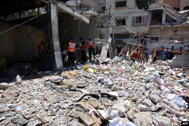 Pegawai kotamadya Gaza dan beberapa pekerja pertahanan sipil memeriksa lokasi tersebut setelah pemboman militer Israel terhadap garasi Kotamadya Gaza di Jalan al-Wahda, di lingkungan al-Daraj di Kota Gaza pada 21 Juni 2024. (Foto: AFP)