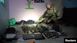 FILE —Israeli military spokesperson Rear Admiral Daniel Hagari shows what he says are weapons stored by Hamas in the basement of Rantissi Hospital at a location given as Gaza, in this image taken from video released November 13, 2023