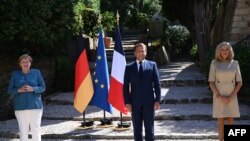 French president Emmanuel Macron and his wife Brigitte Macron (R) welcome German Chancellor Angela Merkel at Fort de Bregancon, in Bormes-les-Mimosas, south-east of France, Aug. 20, 2020. 