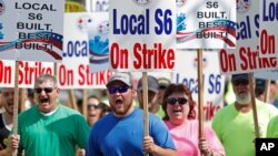  In this July 25, 2020 file photo, striking Bath Iron Works shipbuilders march in solidarity in Bath, Maine.