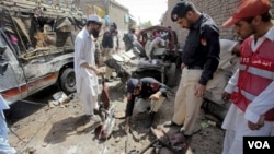 Polisi Pakistan memeriksa lokasi pemboman di tempat pemberhentian bus di Matani, dekat Peshawar (5/6).