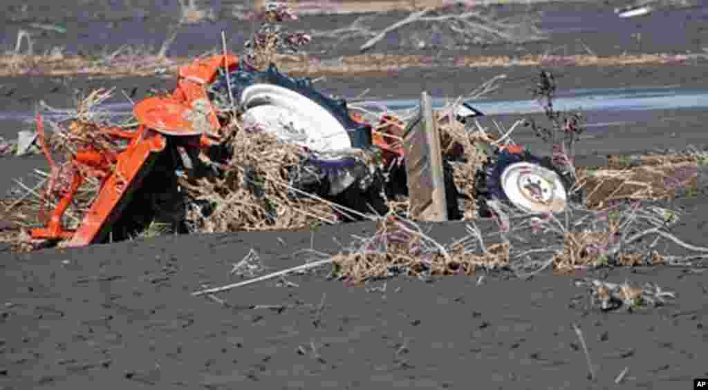 A tractor remains partly buried in mud from the tsunami, Namie, Fukushima Pref., Japan March 12 2011 (VOA - S. L. Herman)