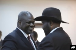 FILE - South Sudan President Salva Kiir, right, and opposition leader and now Kiir's deputy, Riek Machar, congratulate each other after a swearing-in ceremony in Juba, South Sudan, Feb. 22, 2020.