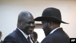 Le président sud-soudanais Salva Kiir, à droite, et le chef de l'opposition et maintenant l'adjoint de Kiir, Riek Machar, se félicitent après une cérémonie d'assermentation à Juba, au Soudan du Sud, le 22 février 2020.