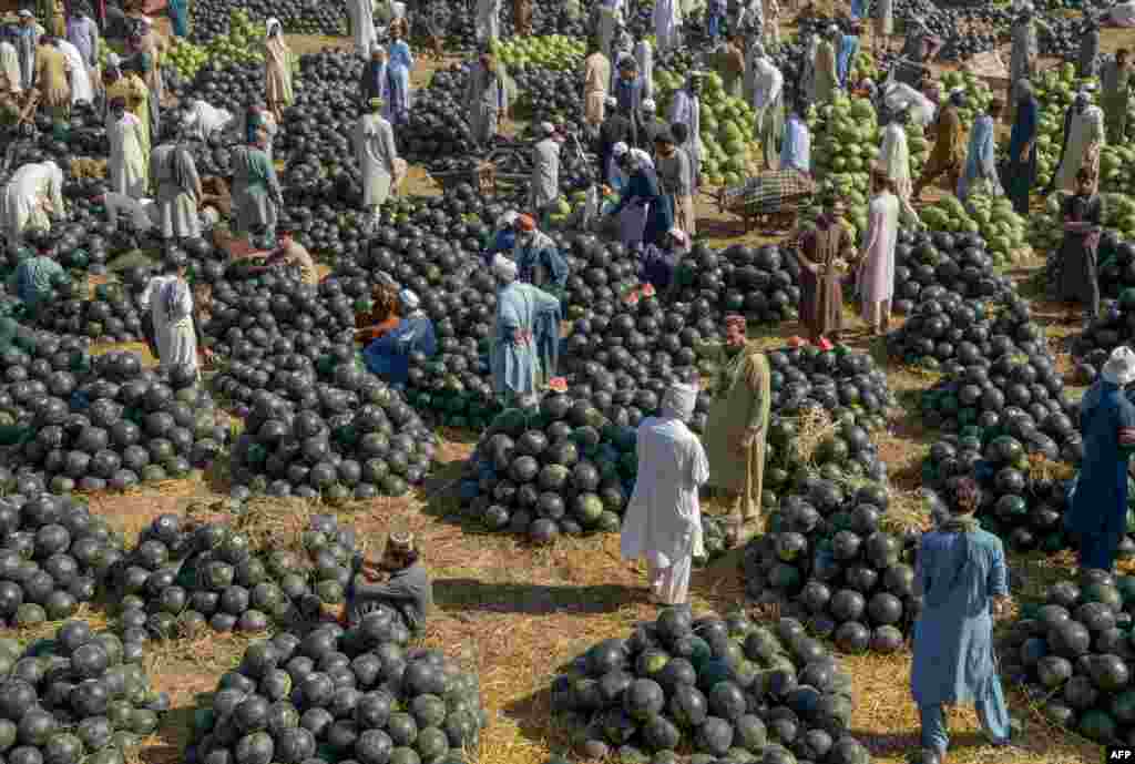 People sell watermelons at a fruit market in Peshawar, Pakistan.