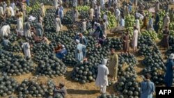 People sell watermelons at a fruit market in Peshawar, Pakistan.