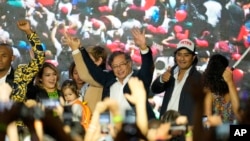 ARCHIVO - El candidato presidencial Gustavo Petro, en el centro, saluda a sus partidarios junto a su hijo Nicolás Petro Burgos, a la derecha, en la noche de las elecciones en Bogotá, Colombia, el 29 de mayo de 2022.