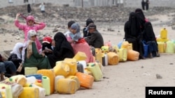 A five-day humanitarian truce in Yemen appeared to be broadly holding Wednesday, as people wait to collect water from a public tap amidst an acute water shortage, in Sana'a, May 13, 2015. 