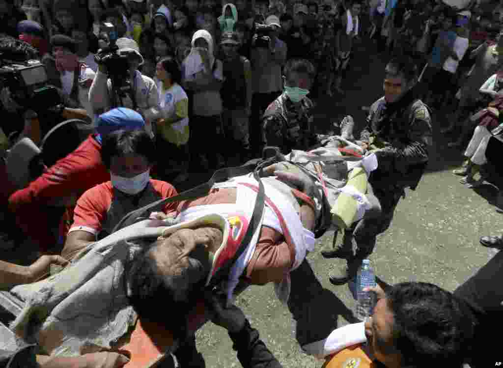 A typhoon survivor is carried into a makeshift clinic after being rescued in New Bataan township, Compostela Valley, Philippines, December 6, 2012. 