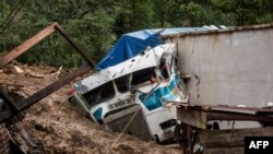 FILE - A truck is covered by mud at the side of a mudslide caused by the passage of Hurricane Eta in Queja, San Cristobal Verapaz, Guatemala, Nov. 7, 2020. Officials on Nov. 14 expressed concern about the approach of Tropical Storm Iota.