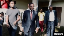 FILE - Maurice Kamto, a presidential candidate of Renaissance Movement (MRC), walks with his staff after his news conference at his headquarter in Yaounde, Cameroon, Oct. 8, 2018. 