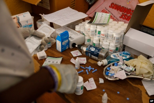 An employee at Sierra Leone Youth Development and Child Link (SLYDCL) provides medical care for Kush users at Moa Wharf, a drug den in Freetown, Sierra Leone, Friday, April 26, 2024. (AP Photo/ Misper Apawu)