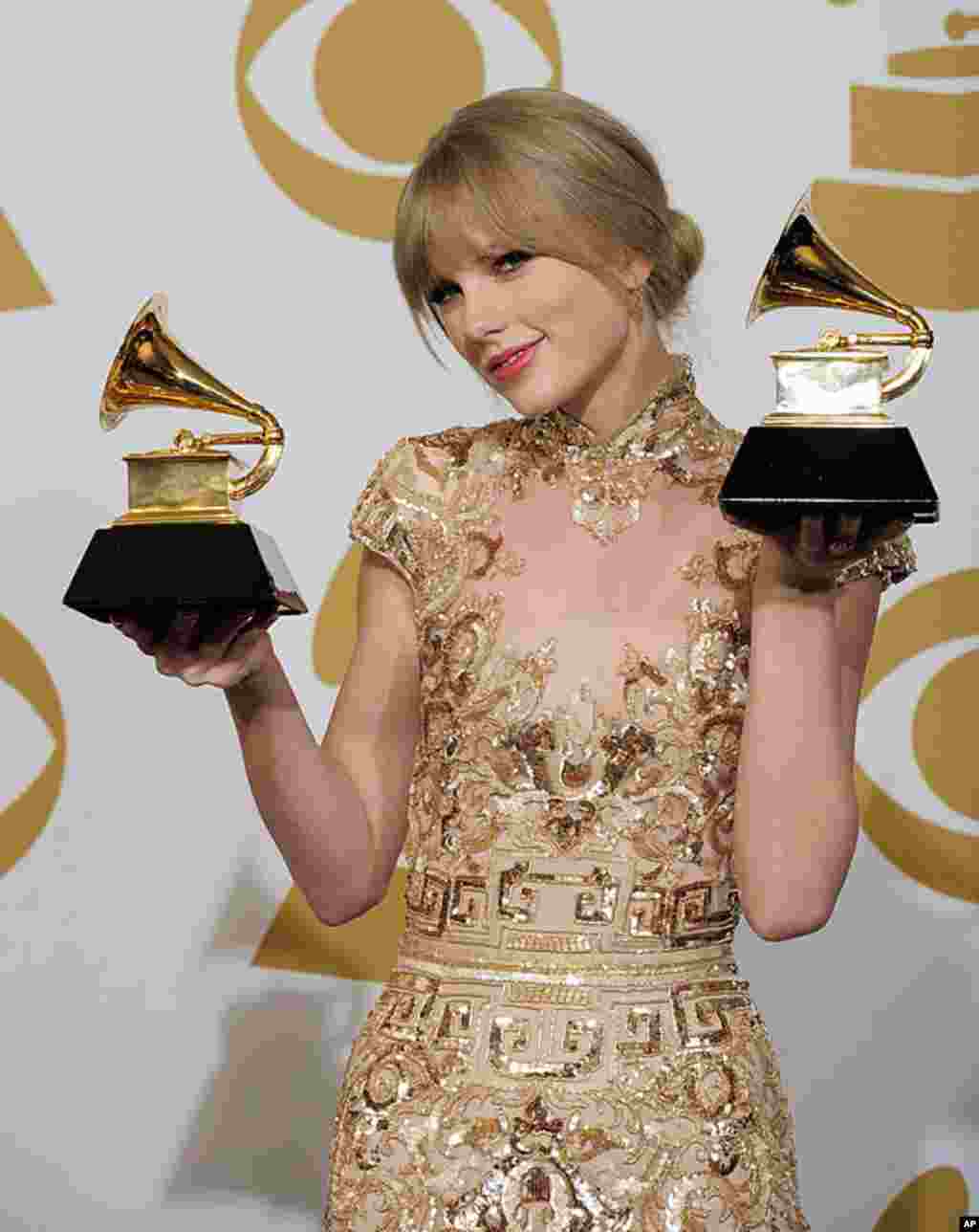 Taylor Swift poses backstage with the awards for best country song and best country solo performance for "Mean" at the 54th annual Grammy Awards in Los Angeles, February 12, 2012. (AP Photo/Mark J. Terrill)