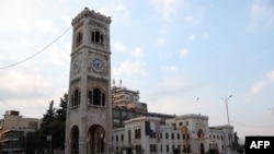 A man rides a bicycle past the landmark clock tower of the central Syrian city of Hama on Jan. 27, 2025. 