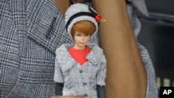 In this Nov. 5, 2018 photo, model Tiffany Hendrix holds a Barbie doll while wearing a matching outfit by designer Katie Echeverry in New York. 