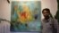 Chhim Sothy, a Cambodian artist, pose in front of his painting at the launching of his exhibition called "Consuming Passion" at the Plantation Hotel in Phnom Penh, Cambodia, on June 25, 2015. 