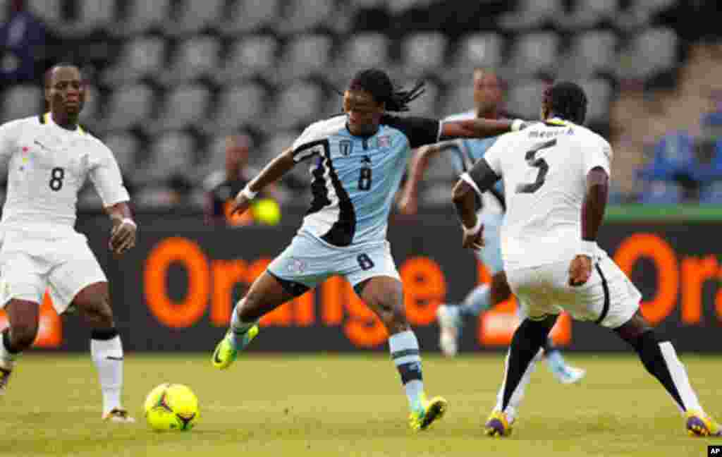 Botswana's Phenyo Mongala challenges John Mensah and Emmanuel Agyemang-Badu of Ghana during their African Cup of Nations Group D soccer match in FranceVille Stadium