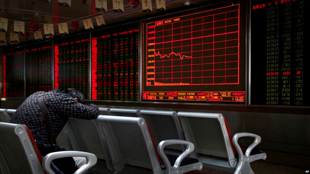 Seorang investor tertidur depan layar elektronik yang menampilkan informasi harga saham di sebuah perusahaan pialang di Beijing, China, 17 September 2018.
