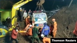 An ambulance is lifted after it was buried in a landslide in Sumedang, West Java, Indonesia, Jan. 9, 2021, in this still image taken from a video obtained from social media. (Rescue Motor Indonesia/via Reuters)