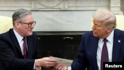 El primer ministro británico Keir Starmer entrega una carta del rey Carlos de Gran Bretaña al presidente estadounidense Donald Trump mientras se reúnen en la Oficina Oval de la Casa Blanca en Washington, D.C., EE.UU., el 27 de febrero de 2025. REUTERS