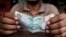 A cashier at an Indian restaurant counts money in New Delhi, India, June 13, 2013. 