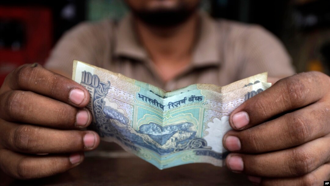 A cashier at an Indian restaurant counts money in New Delhi, India, Thursday, June 13, 2013. 