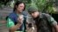A health agent from Sao Paulo's Public health secretary shows an army soldier Aedes aegypti mosquito larvae that she found during clean up operation against the insect, which is a vector for transmitting the Zika virus, in Sao Paulo, Brazil, Jan. 20, 2016