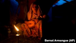 A Rohingya ethnic minority woman cradles her child at a temporary makeshift camp after crossing over from Myanmar into the Bangladesh side of the border, near Cox's Bazar's Gundum area, Saturday, Sept. 2, 2017. 