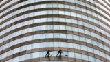 Workers clean glass panels at the west tower of the World Trade Center in Colombo, Sri Lanka.