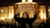 A woman holds up a sign at a vigil for the victims of Wednesday's attack, at Trafalgar Square in London, March 23, 2017. The Islamic State group has claimed responsibility for an attack by a man who plowed an SUV into pedestrians and then stabbed a police officer to death.