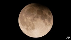 This file image shows a supermoon with a partial lunar eclipse rises over Lake Michigan in Chicago, Tuesday, Sept. 17, 2024. (AP Photo/Kiichiro Sato, File)