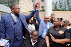 عدالت کے فیصلے کے بعد سیاہ فاموں کے کونسلر مالک شہباز(بائیں) اور ان کے ساتھ کونسلر ٹرینٹ والکر خوشی کا اظہار کر رہے ہیں۔ 21 مارچ 2024
