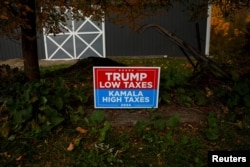 A sign supporting former U.S. President Donald Trump stands posted in the election battleground Erie County township of North East, Pennsylvania, Oct. 23, 2024.