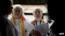 Bridget Mary Meehan, right, an American co-founder of the Association of Roman Catholic Women Priests, takes part in a secret ordination of six women on a barge on the Tiber River in Rome on Oct. 17, 2024. The ceremony was not authorized by the Vatican.