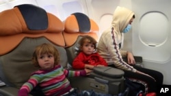 کودکان آلبانیایی که در اردوگاه الهول به سر می‌بردند، سوار بر هواپیما در مسیر بازگشت به کشورشان هستند. (آرشیو)