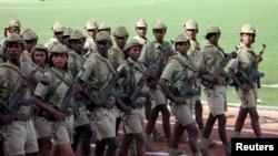FILE - Eritrean soldiers march in Asmara, in May 2007. Eritrea's conscription system forces young people to complete their final year of high school in the desert town of Sawa at a facility that's part school, part boot camp.