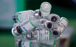 FILE - Empty vials of China's Sinopharm vaccine sit in a cup, Feb. 10, 2021.