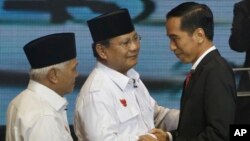 Indonesian presidential candidates Joko Widodo, right, Prabowo Subianto, center, and Subianto's running mate Hatta Rajasa greet each other during a televised debate in Jakarta, June 9, 2014
